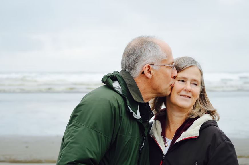 a happy retired couple at the beach feeling confident about the portfolio changes they just made